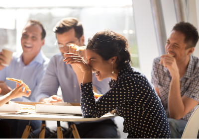 A team of employees laughing over lunch